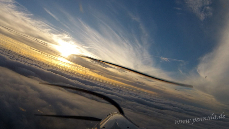 Linkskurve beim Flug über die Wolken zur Sonne hin
